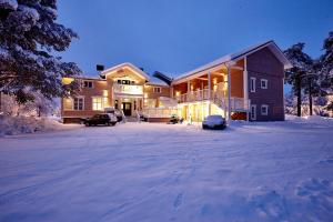 阿尔维斯尧尔拉普兰旅馆的雪中的房子,车道上停有汽车