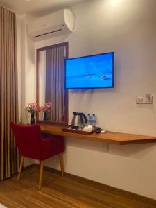 古莉Pearlshine Retreat Maldives的一间设有一张桌子的房间,墙上有一台电视机
