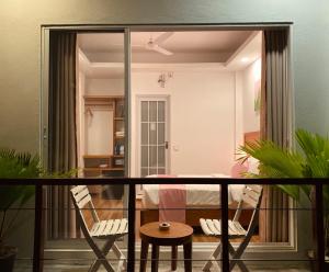 古莉Pearlshine Retreat Maldives的客房设有带2把椅子和1张桌子的阳台。
