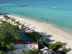 古莉Pearlshine Retreat Maldives的海滩上的人在水中