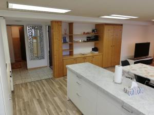 施普吕根Suretta2的厨房配有白色台面和木制橱柜