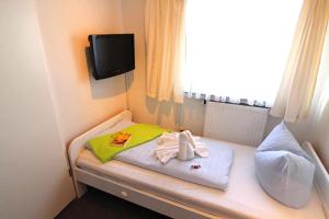 韦斯特兰Kapitaenshaus-Lassen-Zimmer-Kajuete的小房间设有一张带毛巾的床和窗户