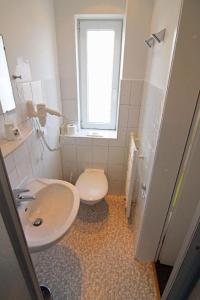 韦斯特兰Kapitaenshaus-Lassen-Zimmer-Kajuete的一间带卫生间、水槽和窗户的浴室