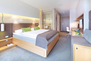 圣彼得奥尔丁斯特兰德古特度假酒店的一间卧室配有一张带绿色枕头的大床