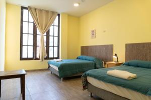伊察Desert Nights Hostel的酒店客房设有两张床和窗户。