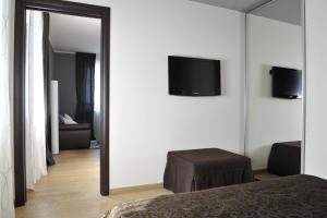 巴巴莱斯科卡萨博法酒店的卧室配有镜子和墙上的电视