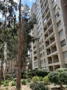 阿尔加罗沃Costa Algarrobo Norte的一座高大的公寓楼,前面有树木
