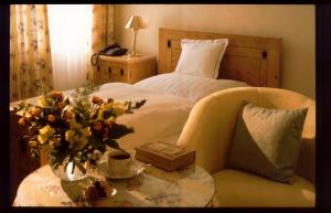 Laubach格贝尔咖啡我们的小酒店的一间卧室配有一张床和一张花瓶桌子