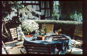 Laubach格贝尔咖啡我们的小酒店的一张桌子,上面有蓝色的桌布,还有椅子