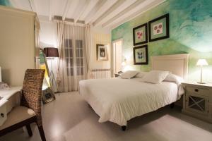 Selores博斯克安佳纳酒店的卧室配有一张白色大床和一把椅子
