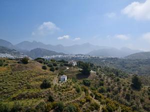 弗里希利亚纳Belvilla by OYO Cortijo Albaricoque的山丘上以山为背景的房子