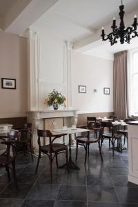 马斯特里赫特圣马丁雅各精品酒店的一间带桌椅和壁炉的用餐室
