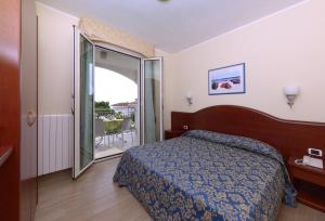 葛伦坦马勒Residence Costa Smeralda的酒店客房设有一张床和一个阳台。