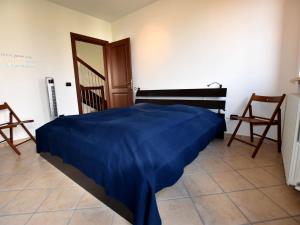 Belvedere LangheBelvilla by OYO La Torre的一间卧室配有一张带蓝色毯子的床