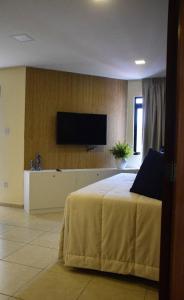 纳塔尔Ana marinho flat 702的一间卧室配有一张床和一台平面电视