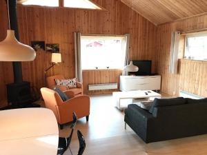 GunsjögårdenChalet in Torsby Municipality Middle with Sauna的客厅配有沙发、椅子和电视