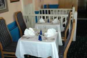 布莱顿霍夫普雷斯顿公园酒店的餐厅设有2张桌子和白色桌布