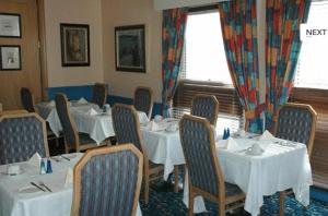 布莱顿霍夫普雷斯顿公园酒店的一间设有白色桌椅的用餐室