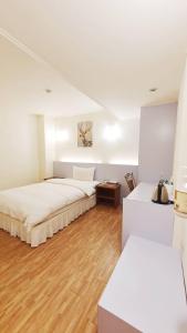 台东苹果商务旅店的一间卧室设有两张床,铺有木地板