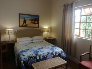 伊丽莎白港山谷宾馆的一间卧室配有一张带蓝白色毯子的床