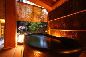 丰冈市西村屋招月庭的窗户客房内的浴缸