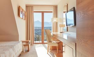 布科维纳-塔钱斯卡斯波尼克卡酒店的酒店客房设有一张书桌、一台电视和一个阳台。