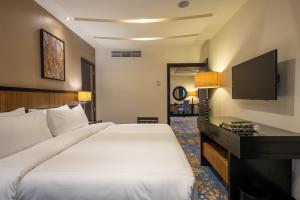 麦加Al Ghufran Safwah Hotel Makkah的酒店客房设有一张大床和一台电视。