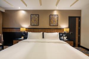 麦加Al Ghufran Safwah Hotel Makkah的一间卧室设有一张大床和两个窗户。