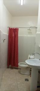 安曼Al Midan Hotel的浴室设有卫生间和红色的淋浴帘