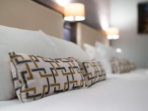 阿克灵顿杜肯哈尔夫布莱克本Spa美居酒店的床上一排枕头