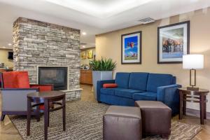 凤凰城Comfort Inn & Suites Phoenix North - Deer Valley的客厅设有蓝色的沙发和壁炉