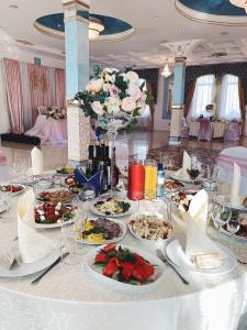 加里宁格勒金色之夜酒店的一张桌子,上面放着食物和鲜花