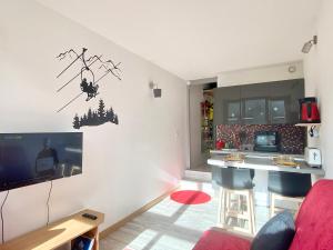 伊索拉2000ISOLA Front de Neige - STUDIO的带电视的客厅和厨房。
