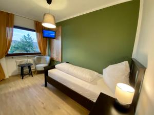 霍兹哈森蓝哥罗迷宾馆的一间卧室配有一张床、一张桌子和一个窗户。