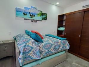 艾库玛尔Riviera Maya Luxury Oceanfront Condo的一间卧室配有一张带蓝色枕头的床