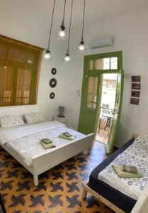 海法Apartments COMFY - for a quiet family holiday的一间卧室设有两张床和一扇绿门