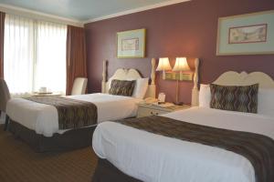 圣巴巴拉奥赛斯套房酒店的酒店客房设有两张床和窗户。