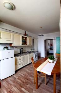 马里博尔Apartma MB-Center的厨房配有白色橱柜、木桌和用餐室。