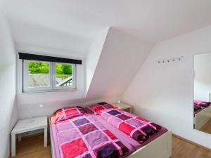 温特贝格Well kept holiday home with terrace的一间卧室配有一张粉红色棉被的床