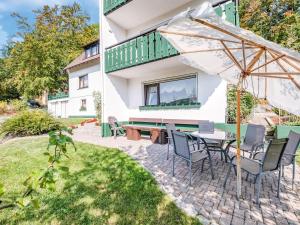 梅德巴赫Apartment with terrace in Sauerland region的庭院配有桌椅和遮阳伞。