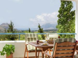 莱弗考基亚Modish Villa in Lefkogia Crete with Swimming Pool的山景阳台上的桌椅