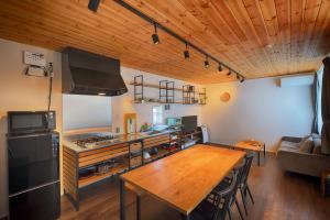 富士河口湖Fujiyasan的厨房以及带木桌的用餐室。