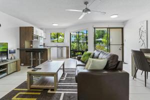努萨维尔Noosa River Retreat Apartments - Perfect for Couples & Business Travel的客厅配有沙发和桌子