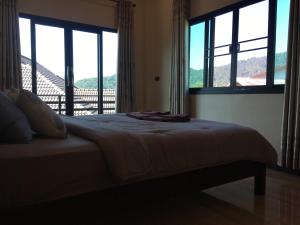 Ban I-Ko Pa Kluaiดอยตุงเฮงธนาโฮมสเตย์的一间卧室设有一张带窗户的床和一个阳台