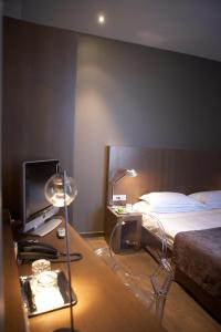 勃姆多莫斯酒店的一间卧室配有一张床和一张书桌及电视