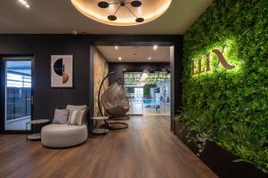 沙罗什保陶克Hotel Bodrog Wellness & Elix Spa的一间设有绿墙、椅子和植物的房间