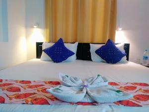 乌代浦Amritchandra homestay and hostel的一间卧室配有一张带蓝色枕头和蓝色弓的床铺