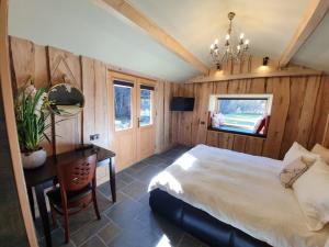 阿祖加Alpin Lodge的一间卧室配有一张床、一张桌子和一张书桌