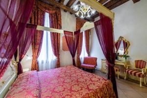威尼斯埃尔凡高酒店的一间卧室配有一张带紫色窗帘的天蓬床