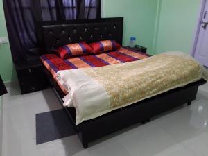 比尔瓦Mohinder & Mohindra Home Stay的卧室内的一张床位,配有黑色床架